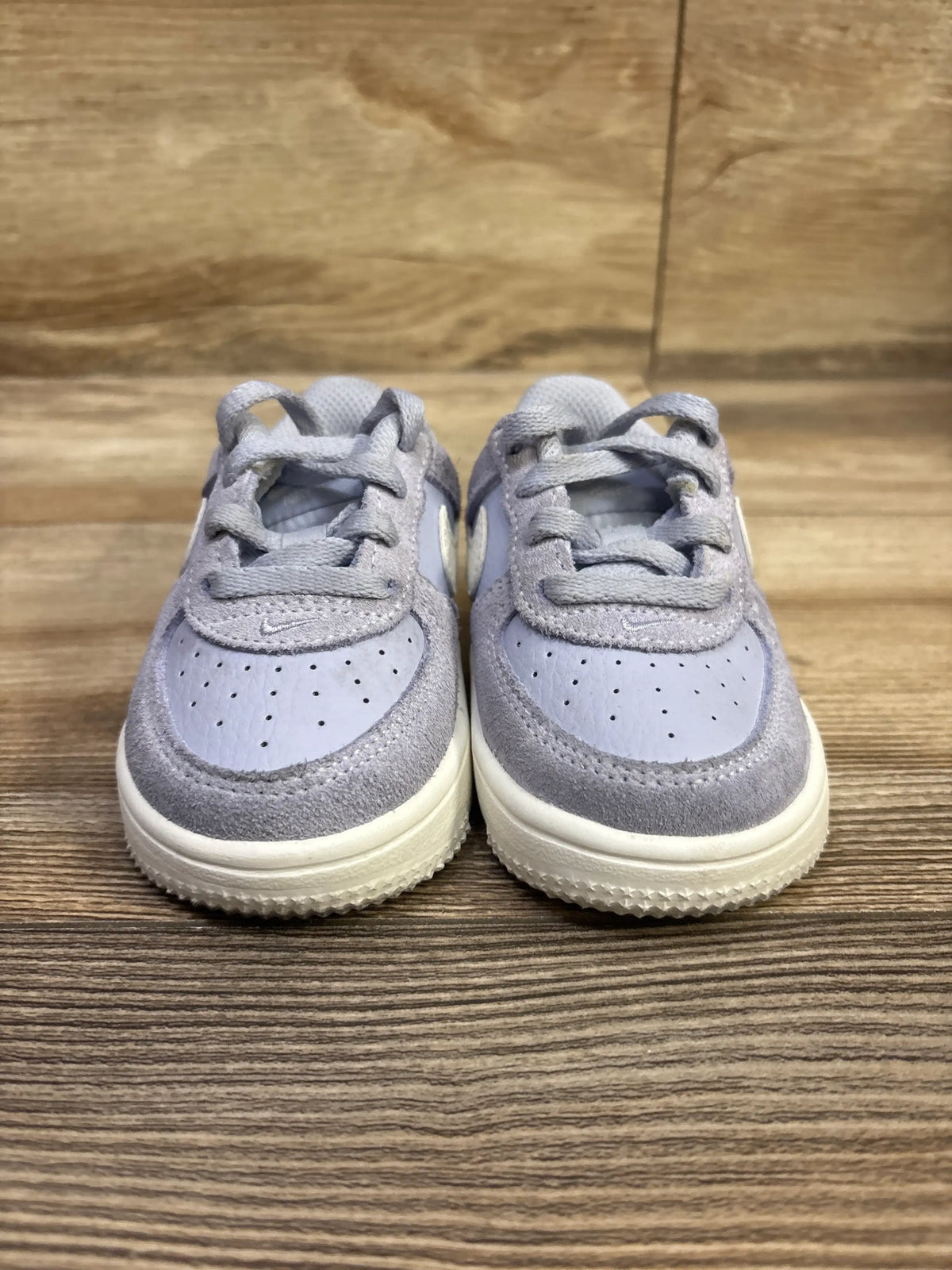 Front view of Nike Force 1 Low LV8 2 TD Ghost Sail sneakers size 5C showing gray uppers and cream soles on wood
