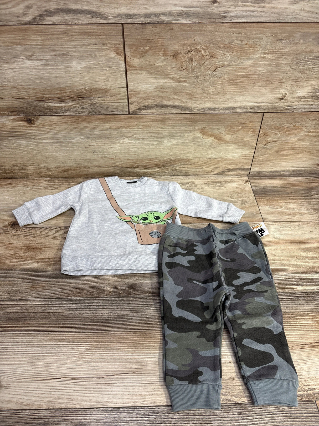 Toddler outfit with Baby Yoda graphic sweatshirt and camo print jogger pants on wood floor