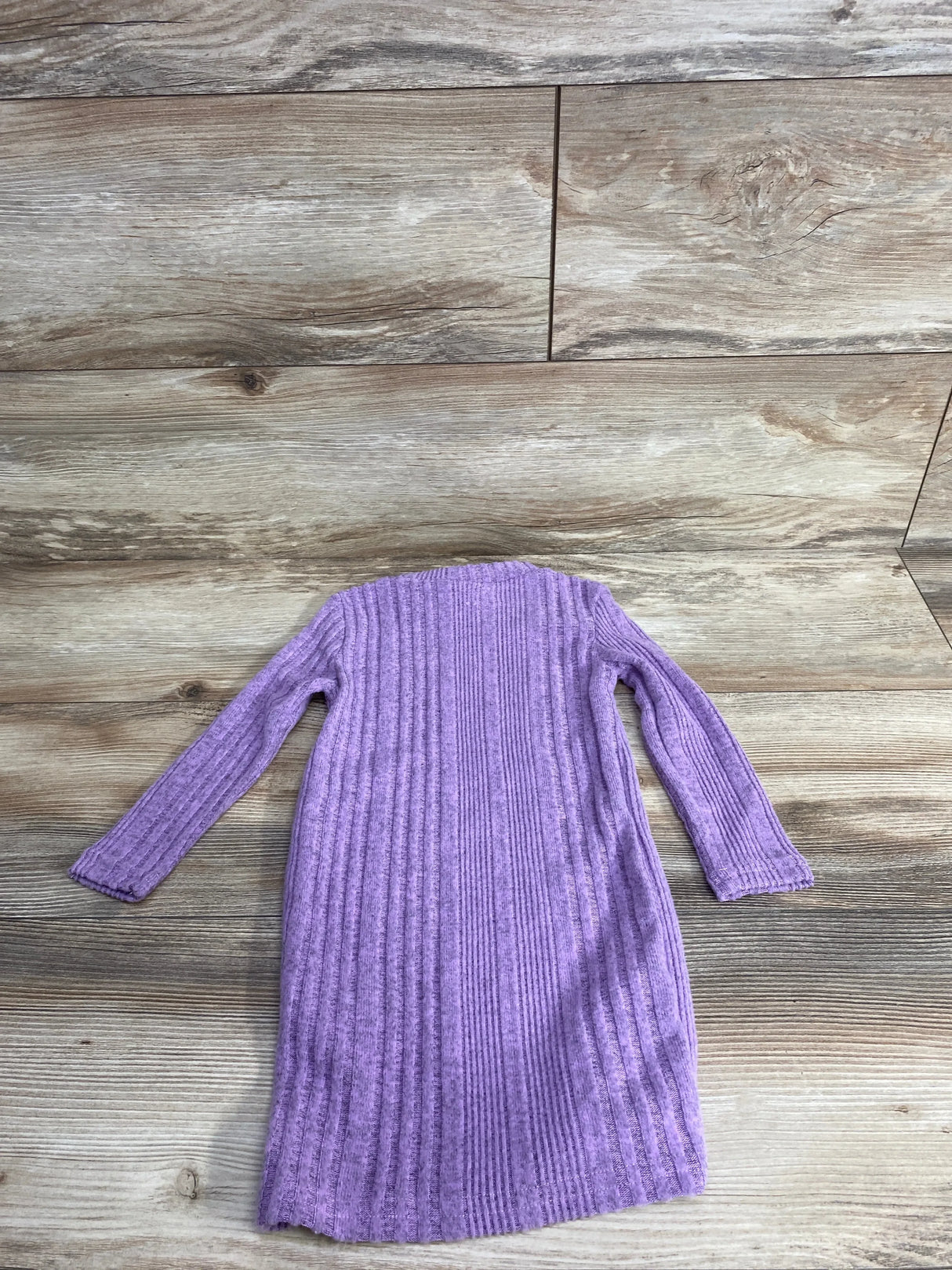 Long sleeve purple ribbed knit girls dress on wood background
