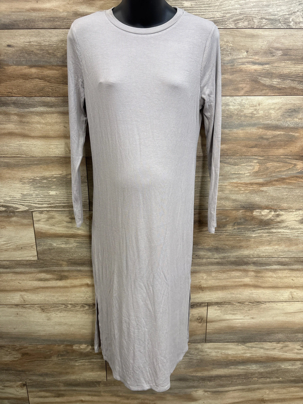 Front view of grey ribbed long-sleeve maternity dress (size M) showing crew neckline, slim fit over bump and side slit on wood background