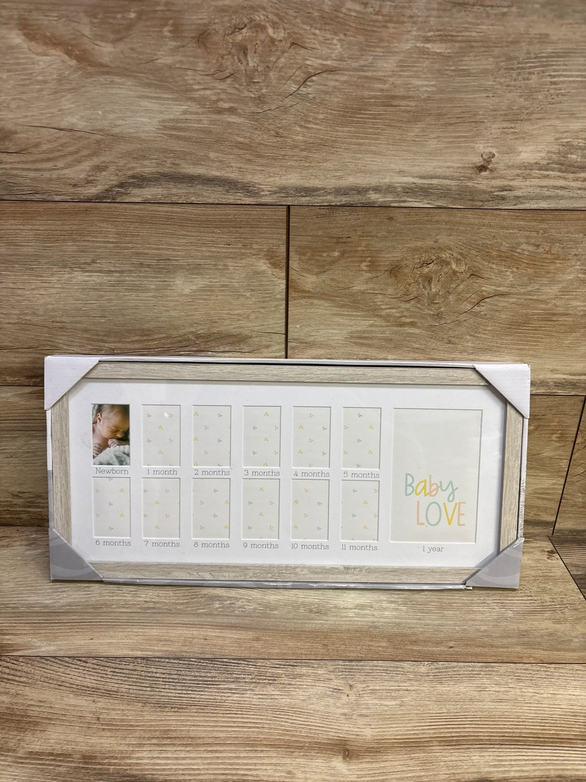Front view of a baby’s first year picture frame with 12 monthly photo openings and a one-year display on wood