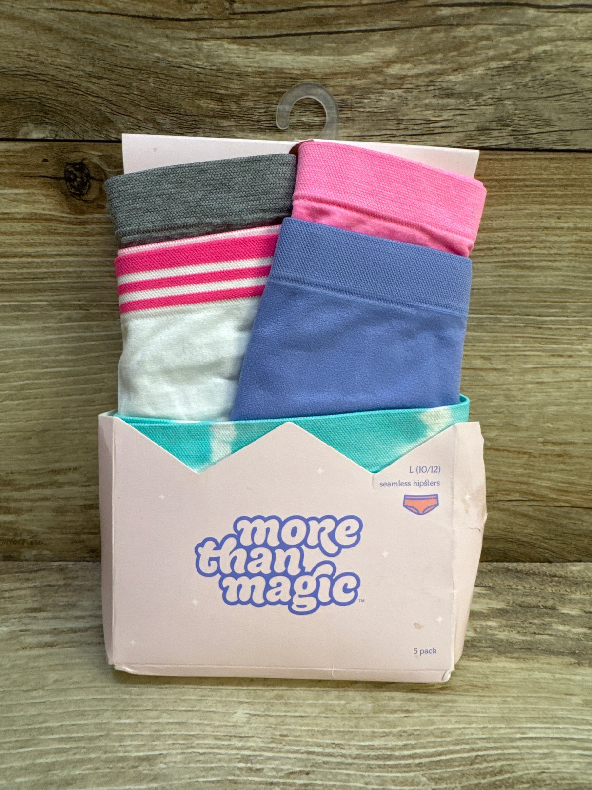 Front view of More Than Magic seamless hipsters 5-pack, size L (10/12), assorted pastels in pink box on wooden background