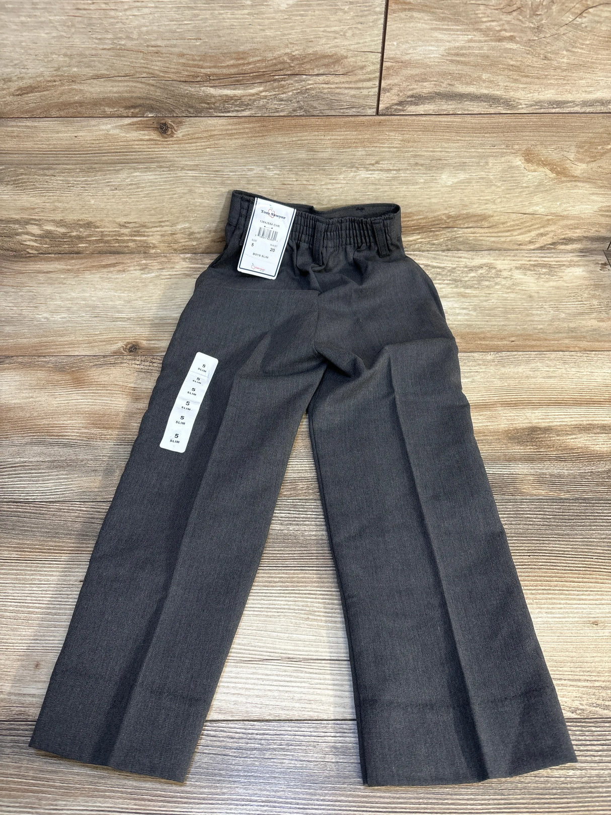 Gray slim-fit boys pants with elastic waist, size 5, laid on wood floor
