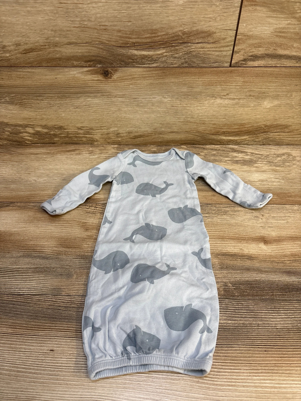 Gray long sleeve infant gown with whale print on wood background, gently used baby clothing