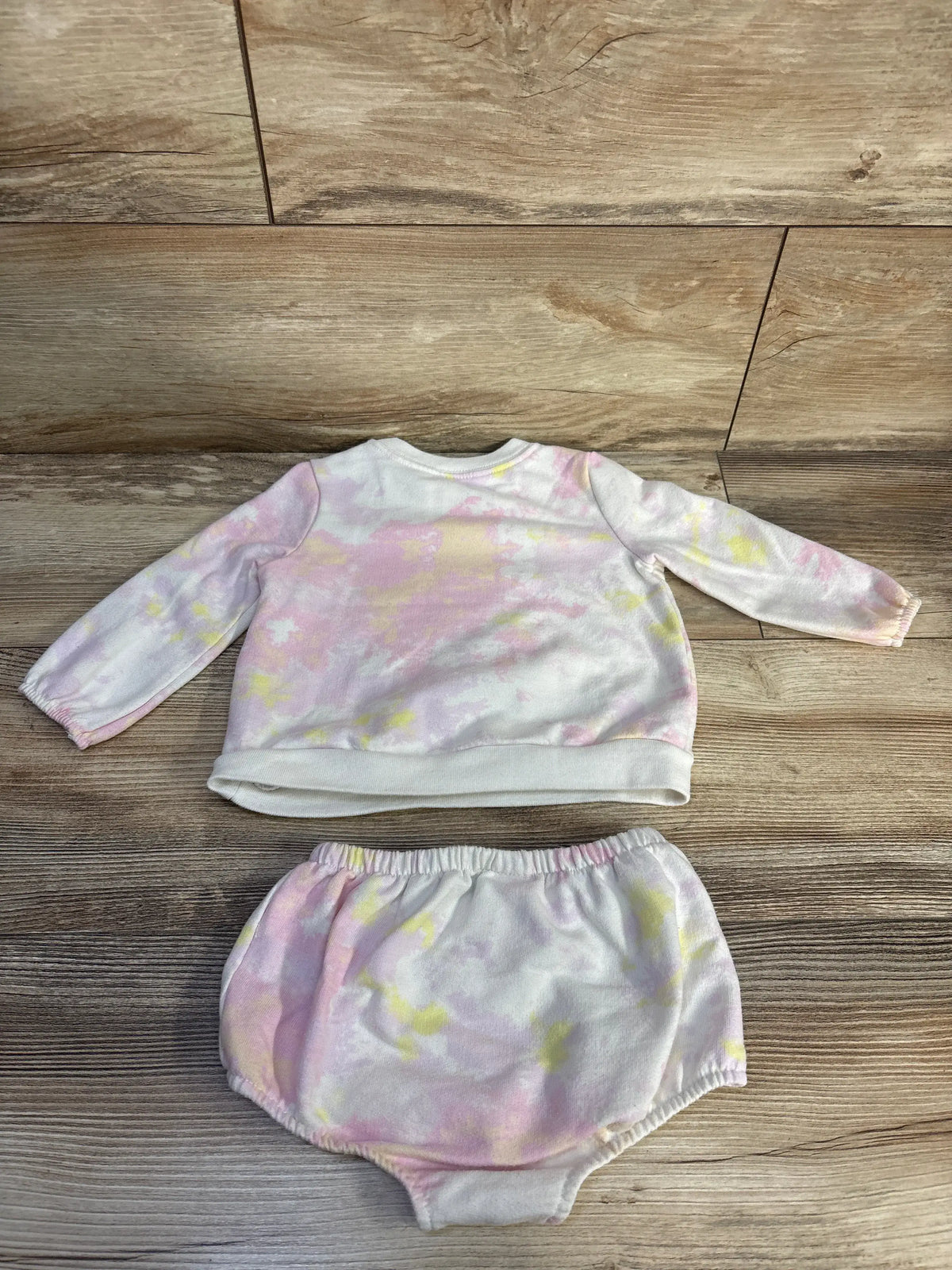 Front view of Cat & Jack tie-dye sweatshirt and bloomers set showcasing pastel tie-dye fabric on a wood floor