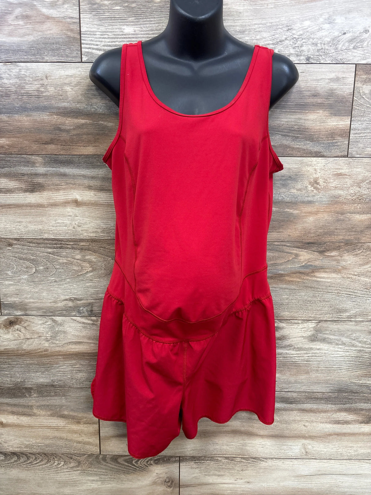 Front view of red Isabel maternity romper (XL) showing scoop neckline, belly panel and shorts on wood background