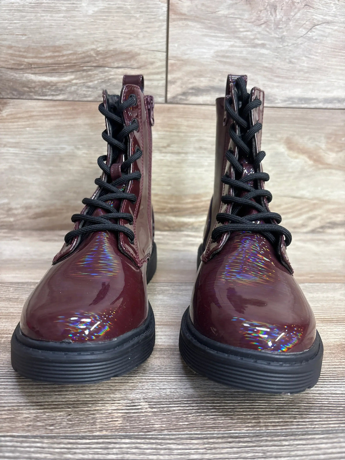 Front view of Art Class Rochelle lace-up combat boots size 4Y showcasing burgundy patent finish, black laces and soles on wood floor