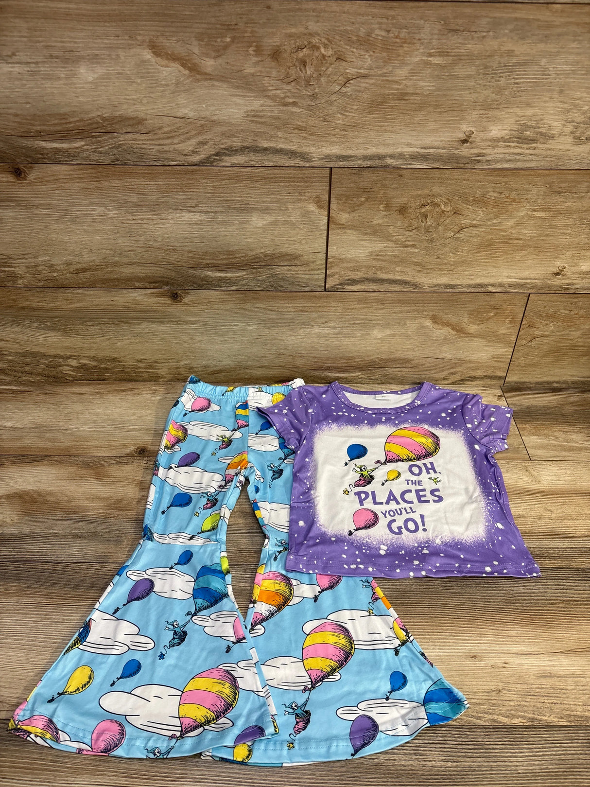 Flat lay of Dr. Seuss 2-piece set size 4T showing purple Oh The Places You’ll Go! tee and blue balloon print bell-bottoms