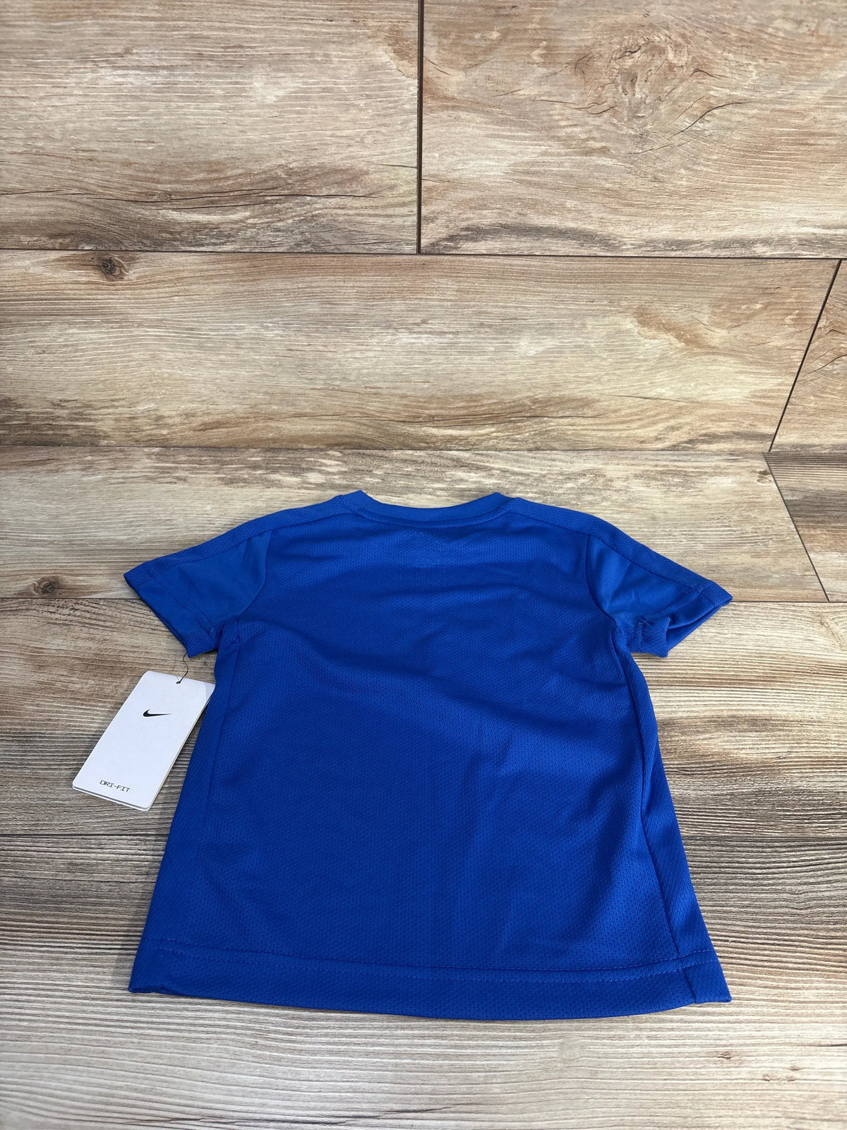 Back view of Nike Dri-Fit shirt in Game Royal Blue, size 3T, showcasing crewneck and short sleeves on wood-grain background