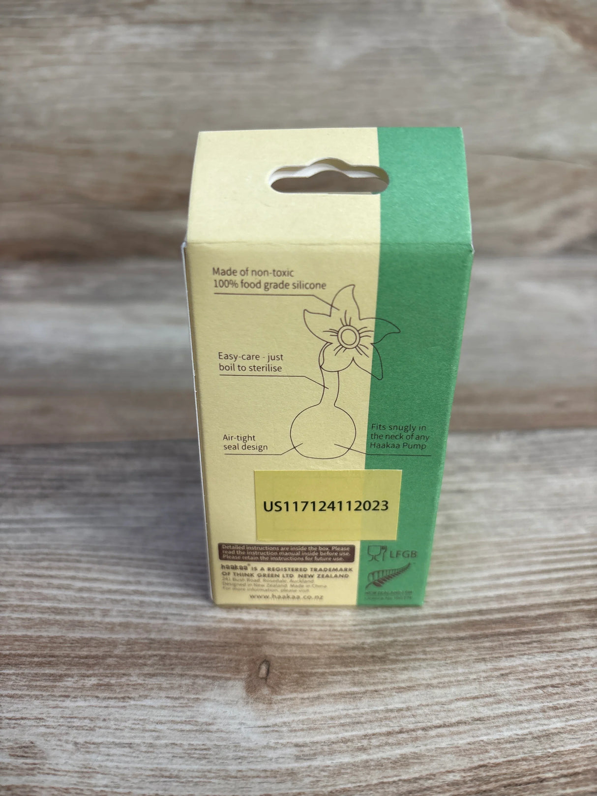 Haakaa silicone breast pump packaging on wood background, with product details and barcode visible.