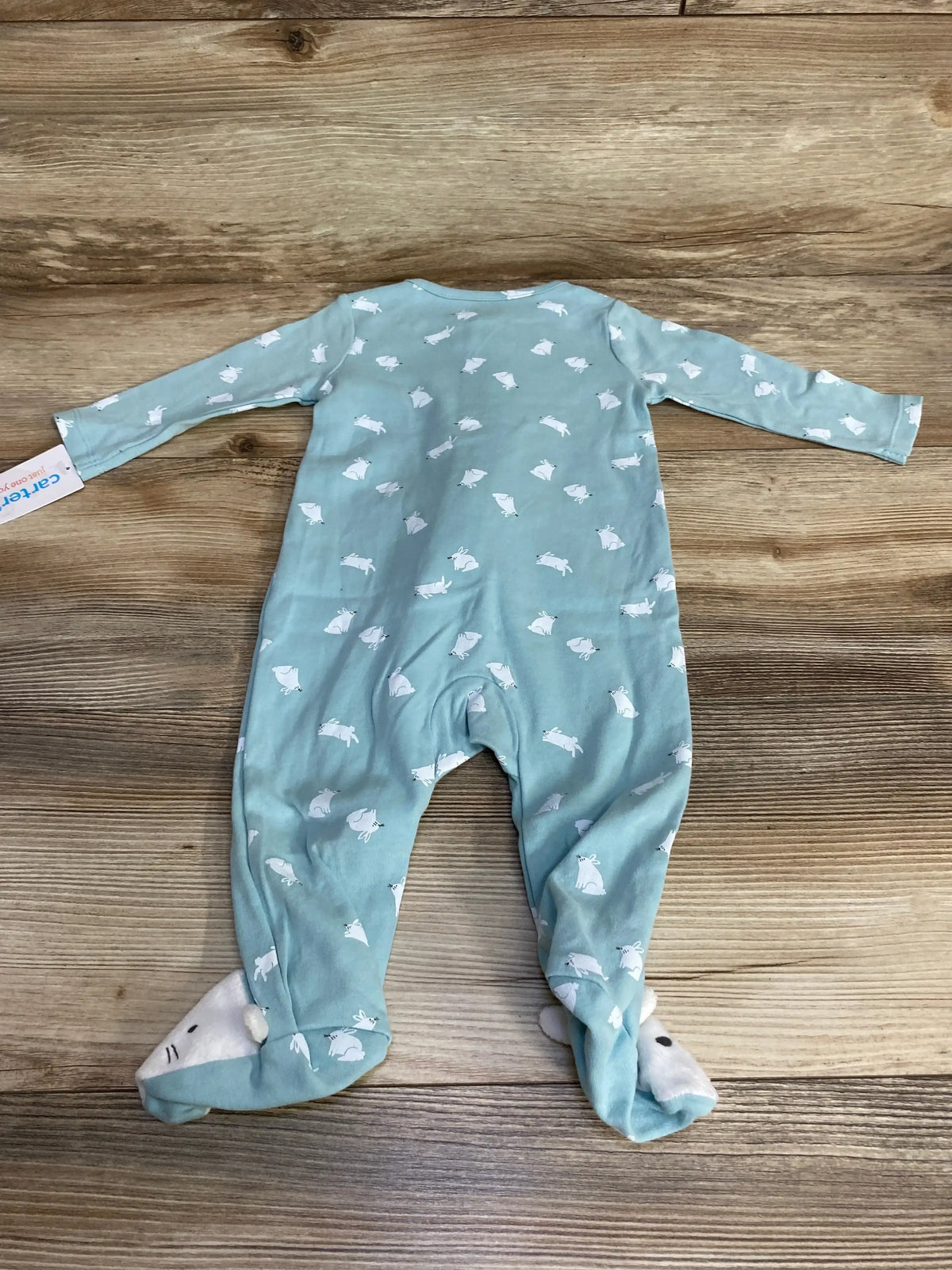 Flat lay of NEW Just One You footed sleeper size 6m showcasing blue bunny print with hangtag and bunny face feet on wood plank floor