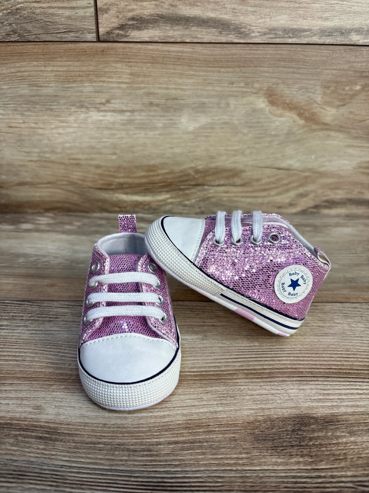 Me n Mommy To Be purple glittery slip-on crib shoes for babies on a wooden surface