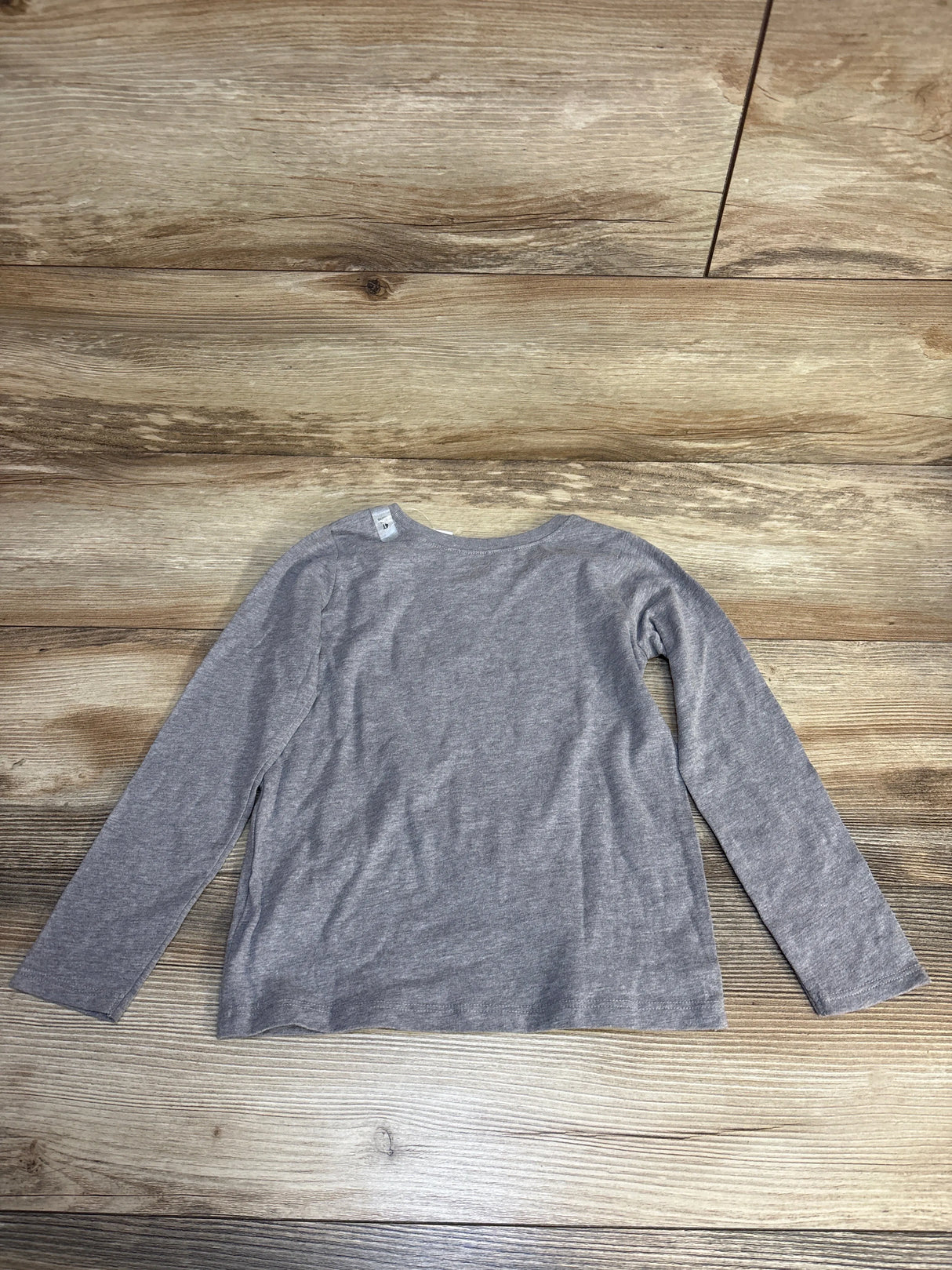 Gray long-sleeve kids shirt on wooden floor, ideal for resale clothing