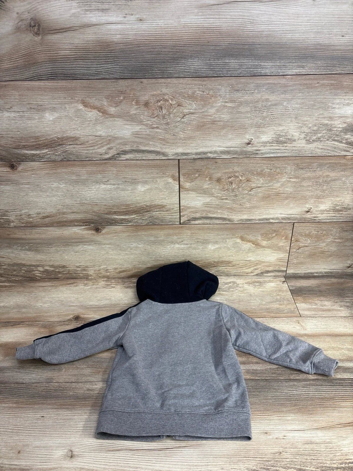 Back view of Carter’s Full Zip Raglan Jacket, size 2T, showcasing navy hood and contrast raglan sleeves on wood background