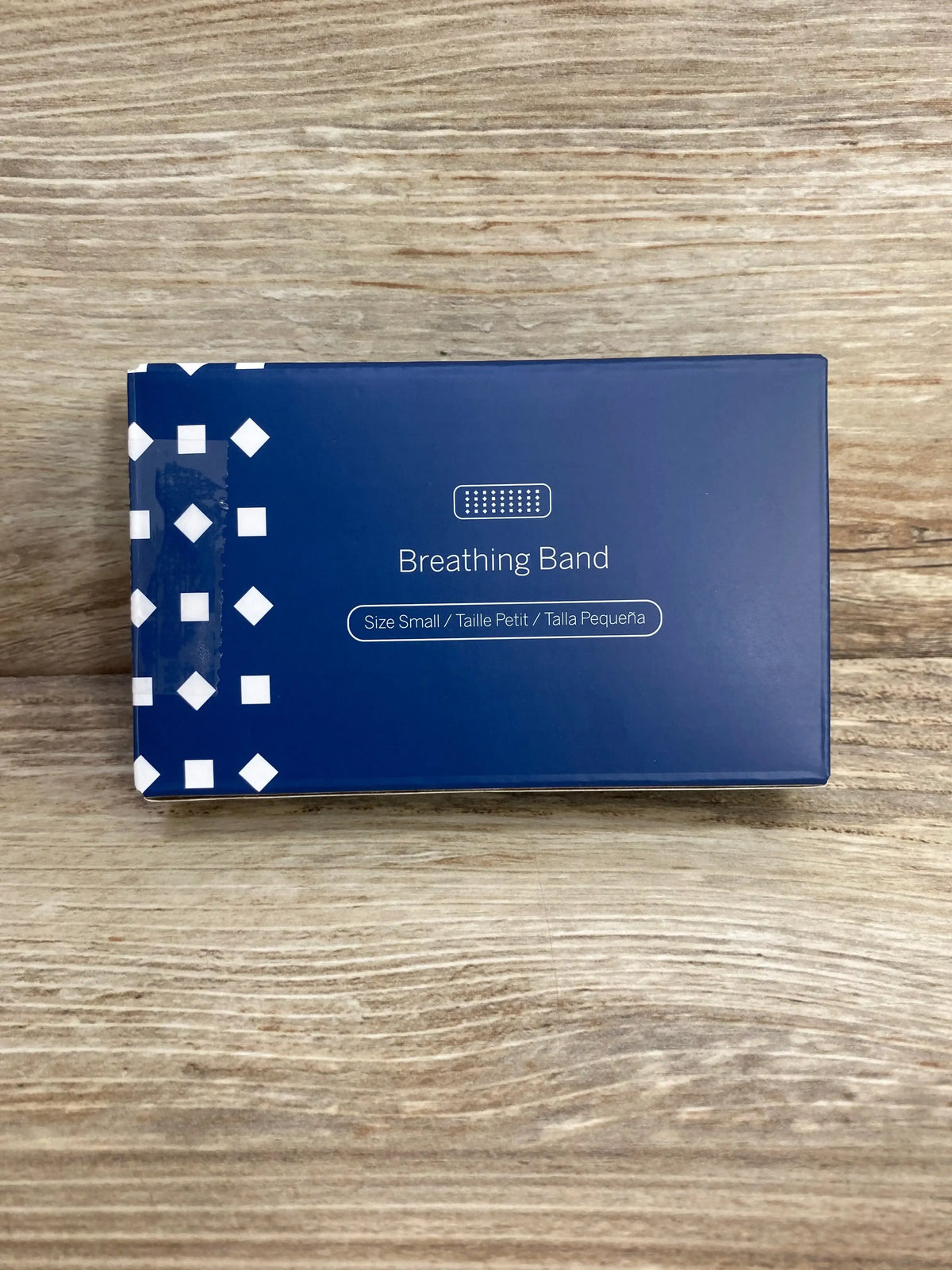 Top-down view of Nanit Breathing Band box showing Breathing Band text and size label Size Small on a wood table