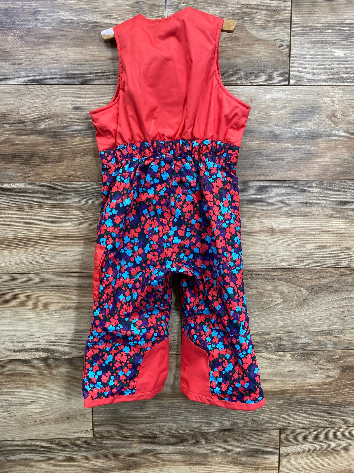 Girls’ floral snow bib pants with red top and colorful blue and red flower print legs