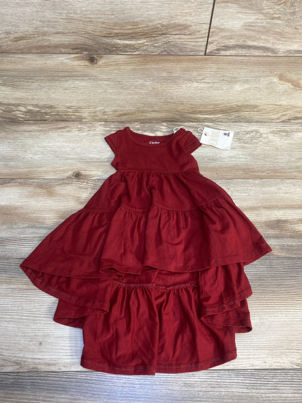Red tiered short sleeve baby dress and matching bloomers on wood background