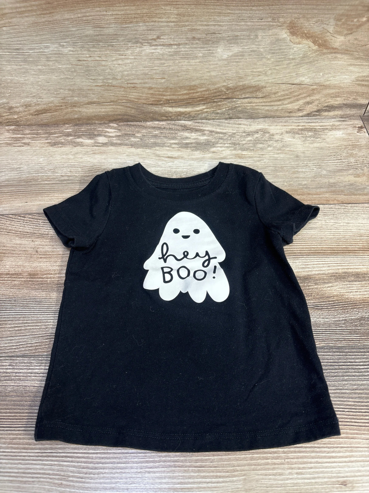 Black toddler Halloween shirt with cute ghost saying 'hey BOO!' on wood background