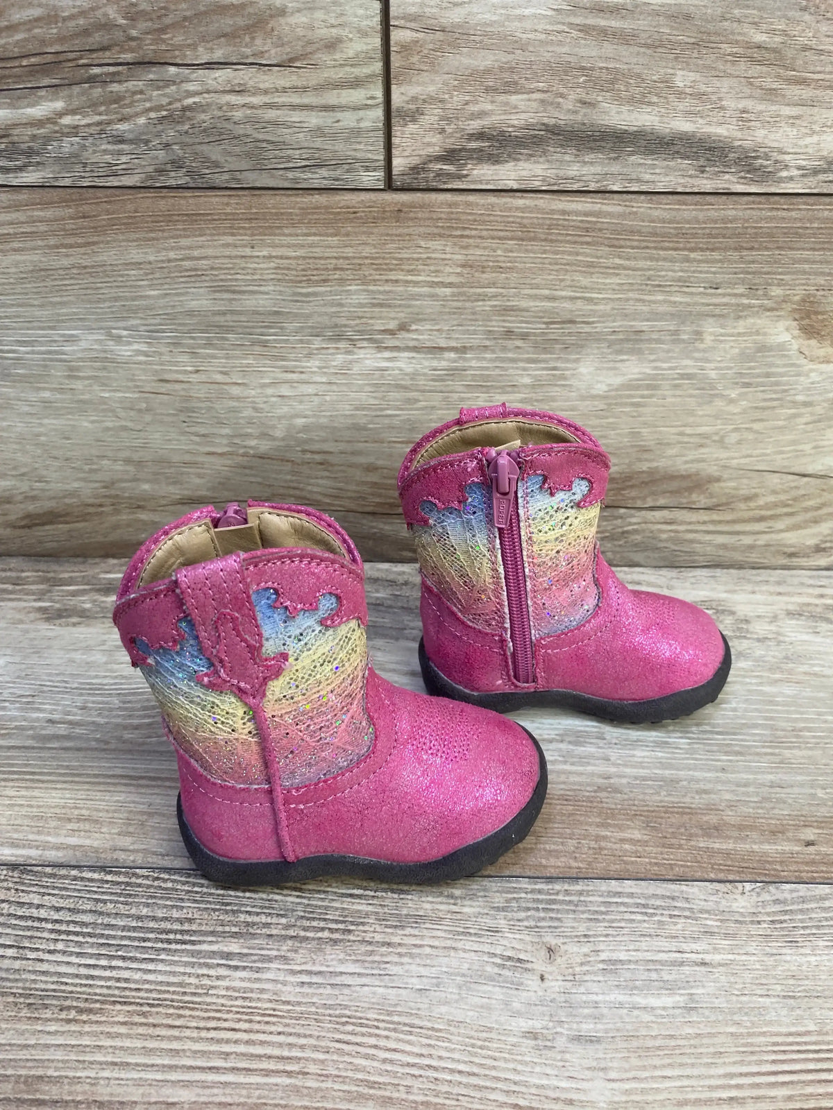 Angled view of Roper infant glitter Cowbabies boots showcasing purple glitter vamp, western stitching, and side zip on a wood background