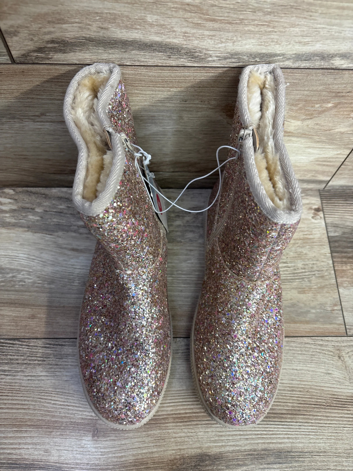 Sparkly glitter kids winter boots with faux fur lining on wood floor