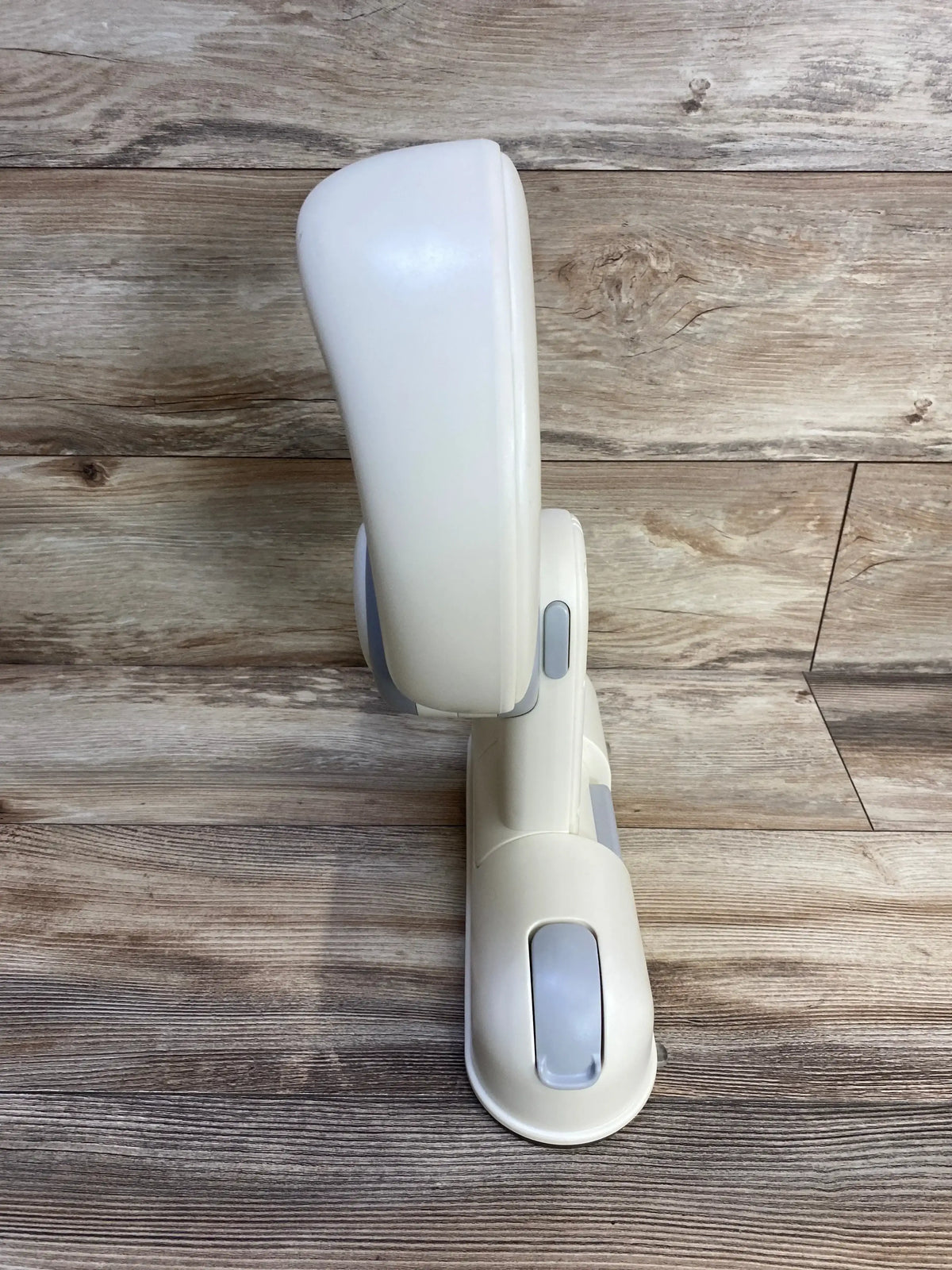 Side view of IvyWind wall-mounted baby shower stand showing adjustable cream plastic bracket with suction-cup mounts on wood backdrop