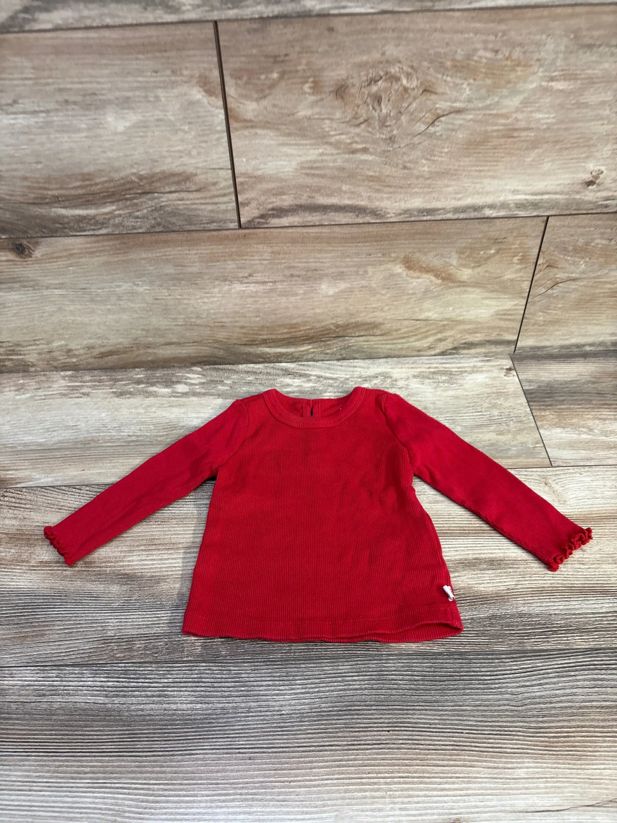Baby Gap ribbed long sleeve red shirt for babies size 6-12m on a wood background