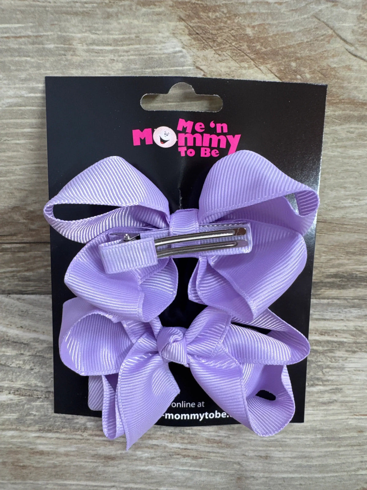 Front view of NEW Medium Hair Bows Lilac 2pk showcasing two grosgrain bows with alligator clips on branded card with wood plank background