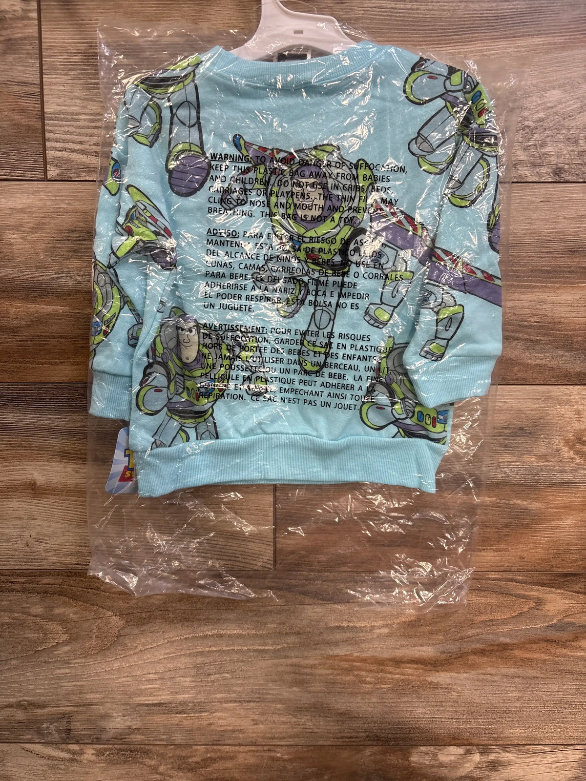 Front view of blue Disney Toy Story Buzz Lightyear sweatshirt, size 2T, with ribbed cuffs and hem in plastic packaging