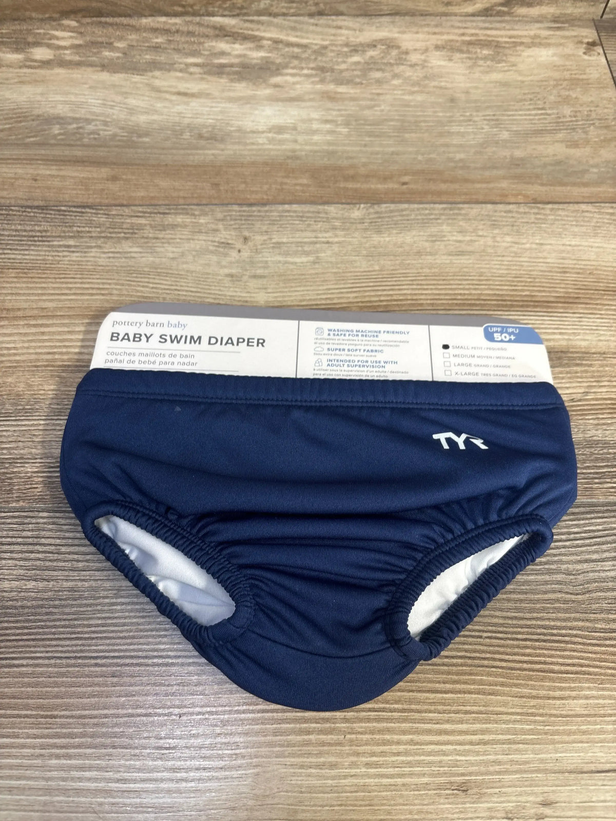 Front view of navy Pottery Barn baby swim diaper showcasing elastic leg openings and TYR logo on wood background