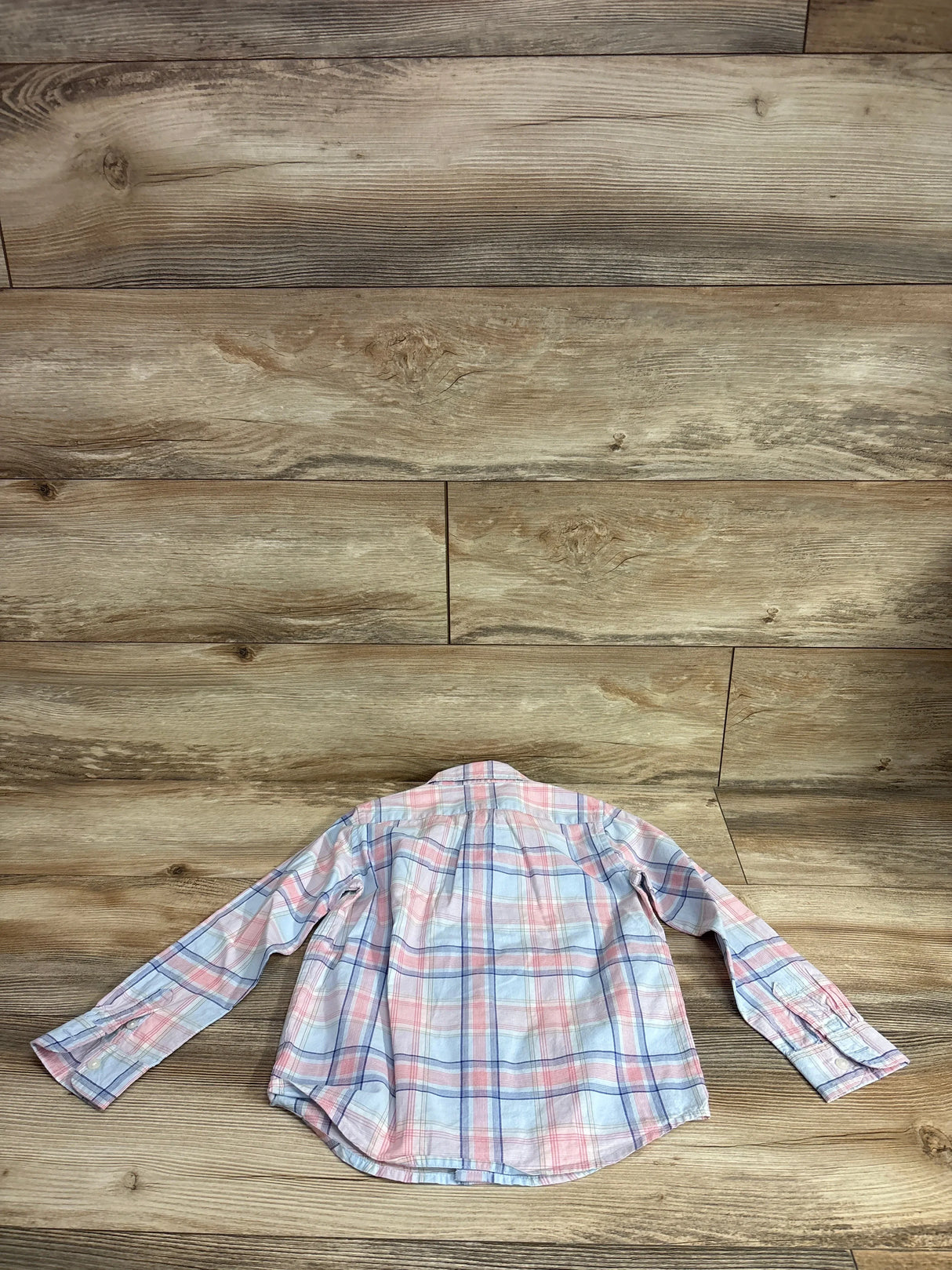 Back view of Janie & Jack plaid poplin button-down shirt in pink and blue showing long sleeves on wood background