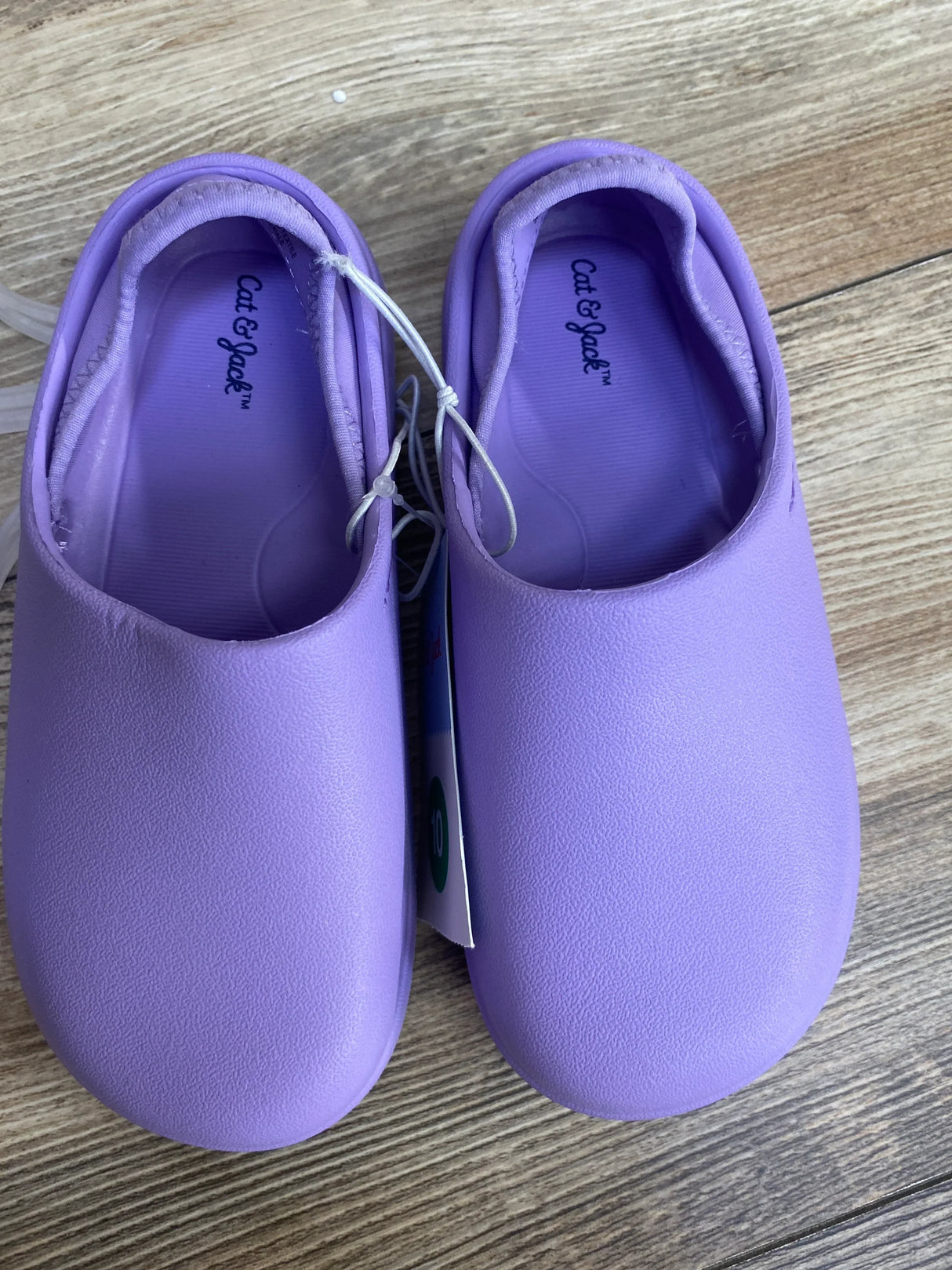 Top-down view of purple Cat & Jack kids' slip-on water shoes showing pair with elastic bungee tie on wood floor