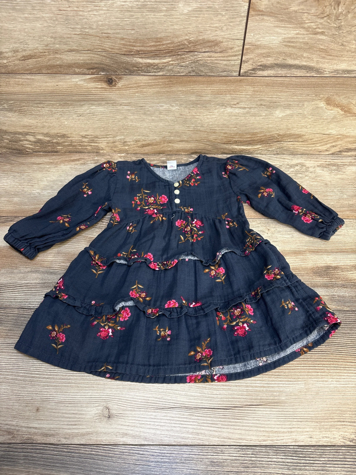 Navy blue long sleeve toddler dress with pink floral print and ruffle details, flat lay