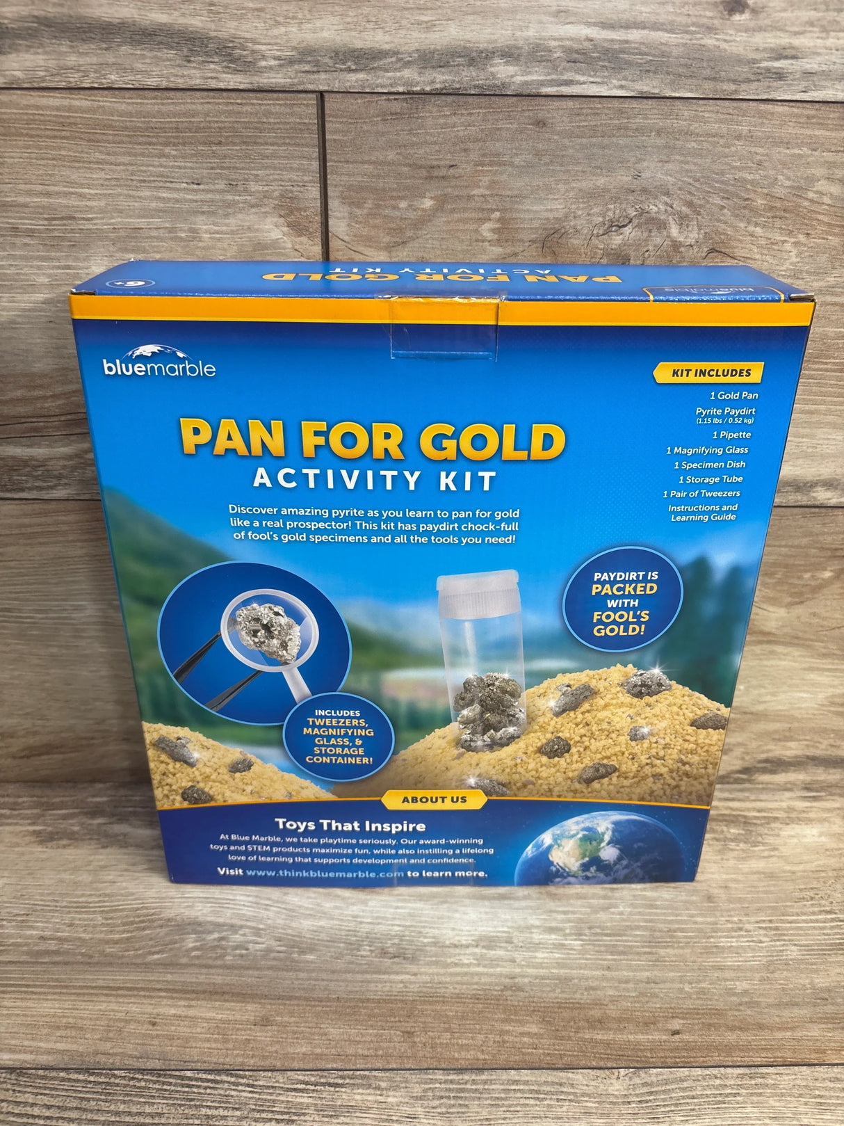 Pan for gold kids activity kit with magnifying glass and tweezers on wood floor