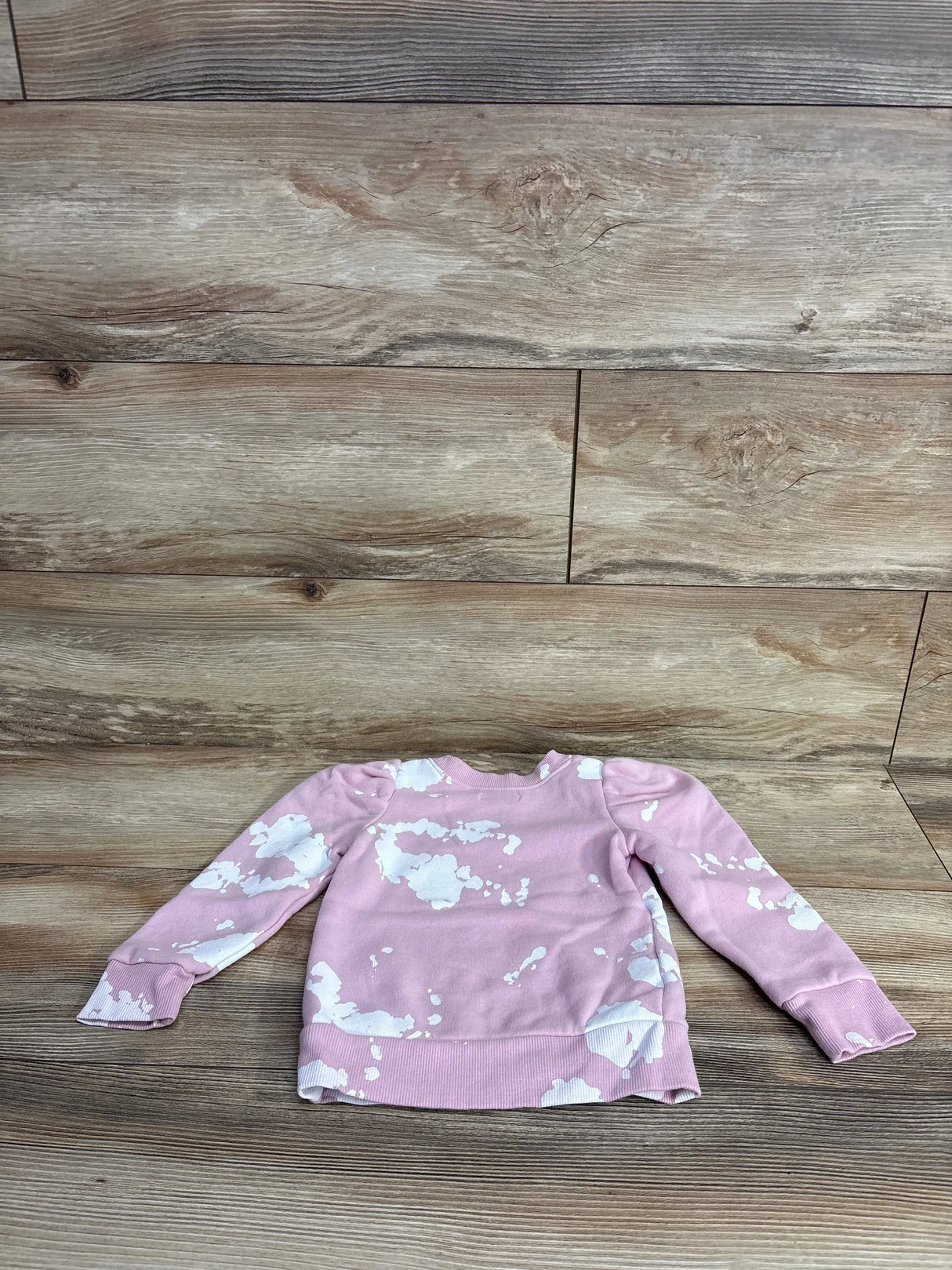 Pink and white tie-dye kids long sleeve sweatshirt on wood background