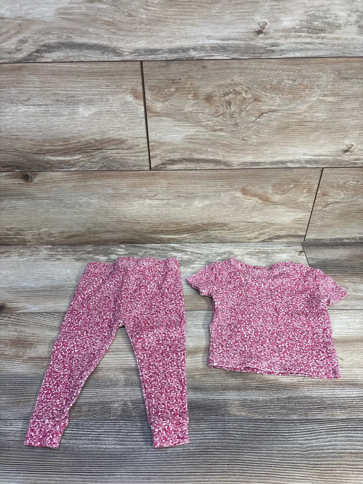 Flat lay of pink Penelope Mack 2-piece pajama set with short-sleeve top and elastic-waist leggings on wood floor