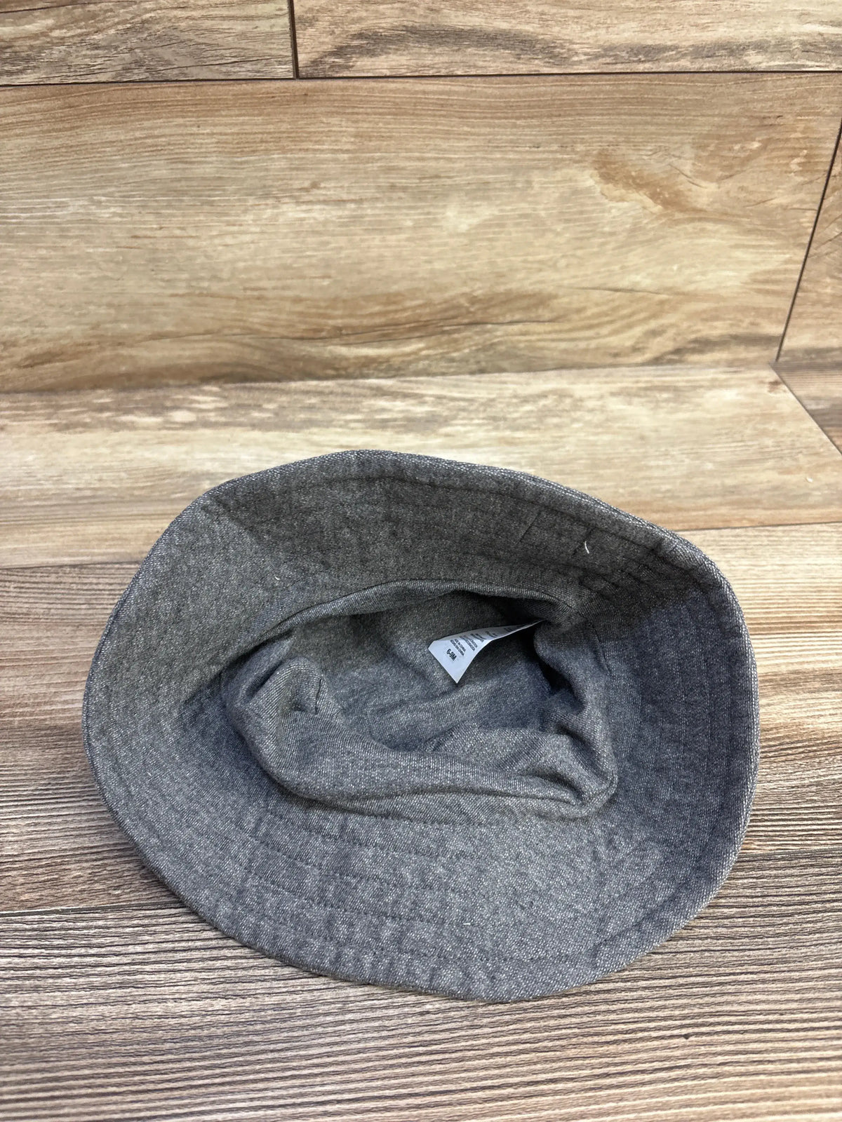 Grey Harry Potter baby bucket hat for size 6-9 months on a wooden background