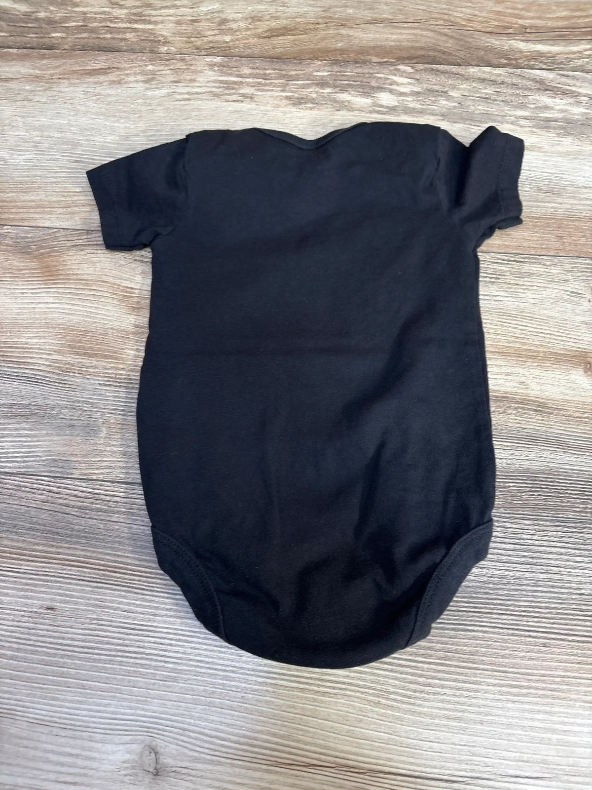 Back view of Circle Clothing You Can Do This Bodysuit Black sz 6m showcasing plain black short-sleeve bodysuit on wood plank background