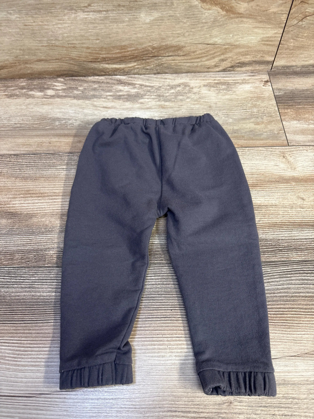 Grey Cat & Jack drawstring pants for baby size 12m laid flat on a wooden surface
