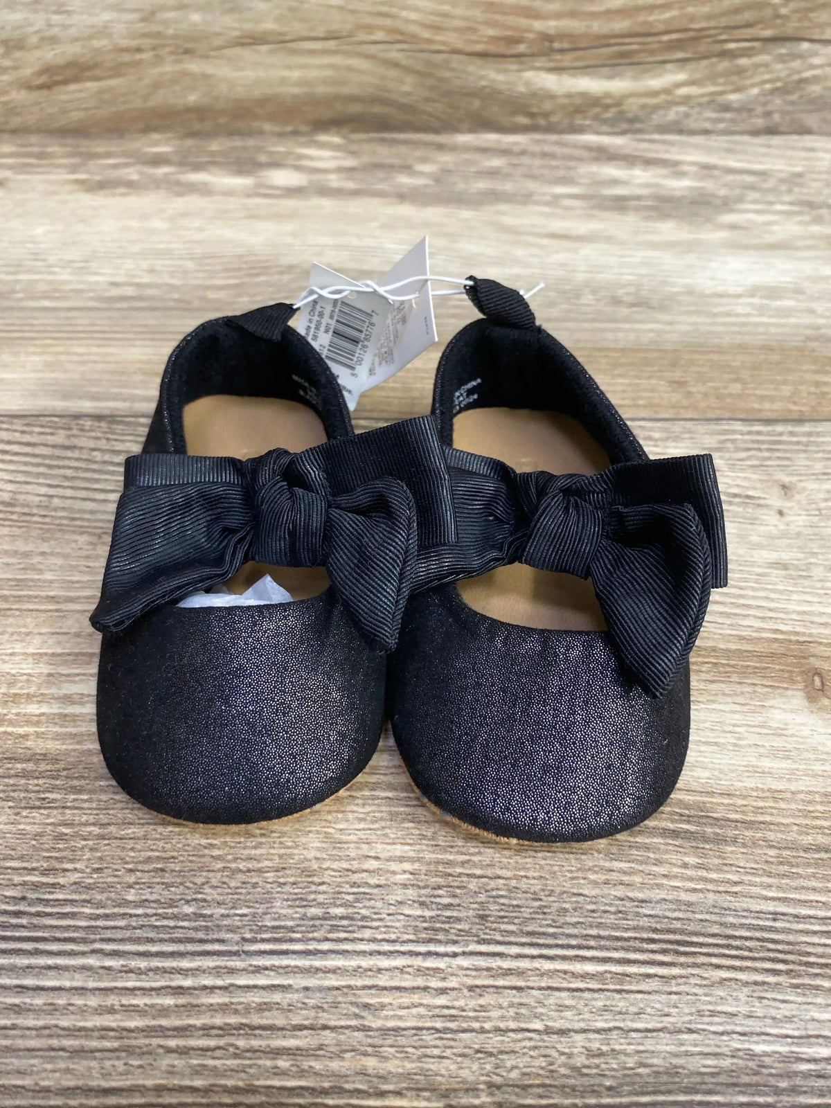Front view of Old Navy black canvas bow ballet flats size 3C showing large grosgrain bows and attached tag on wood background