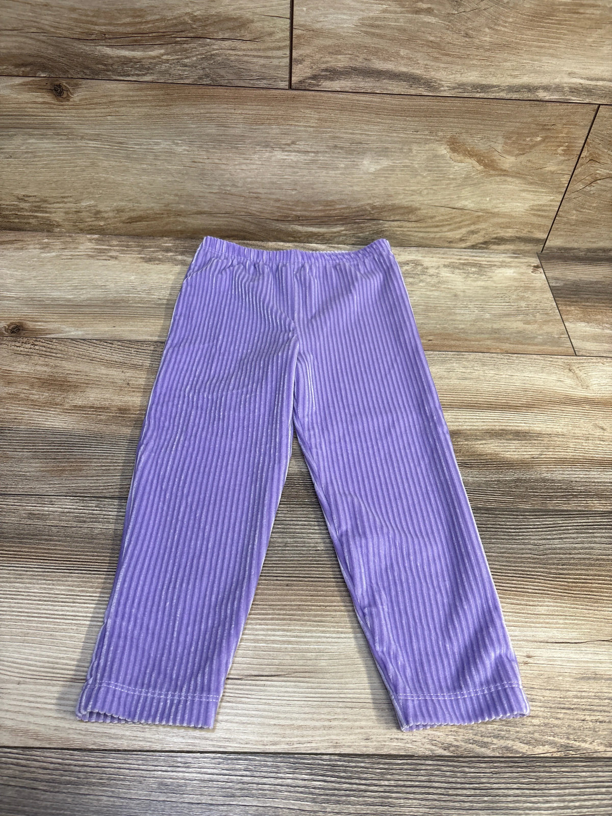 Monica + Andy purple ribbed velour pull-on pants for toddlers on a wooden background