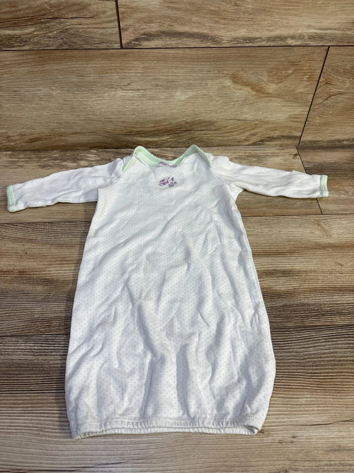 Front view of Little Me white sleep gown showcasing long sleeves, green trim, and floral embroidery on a wood floor