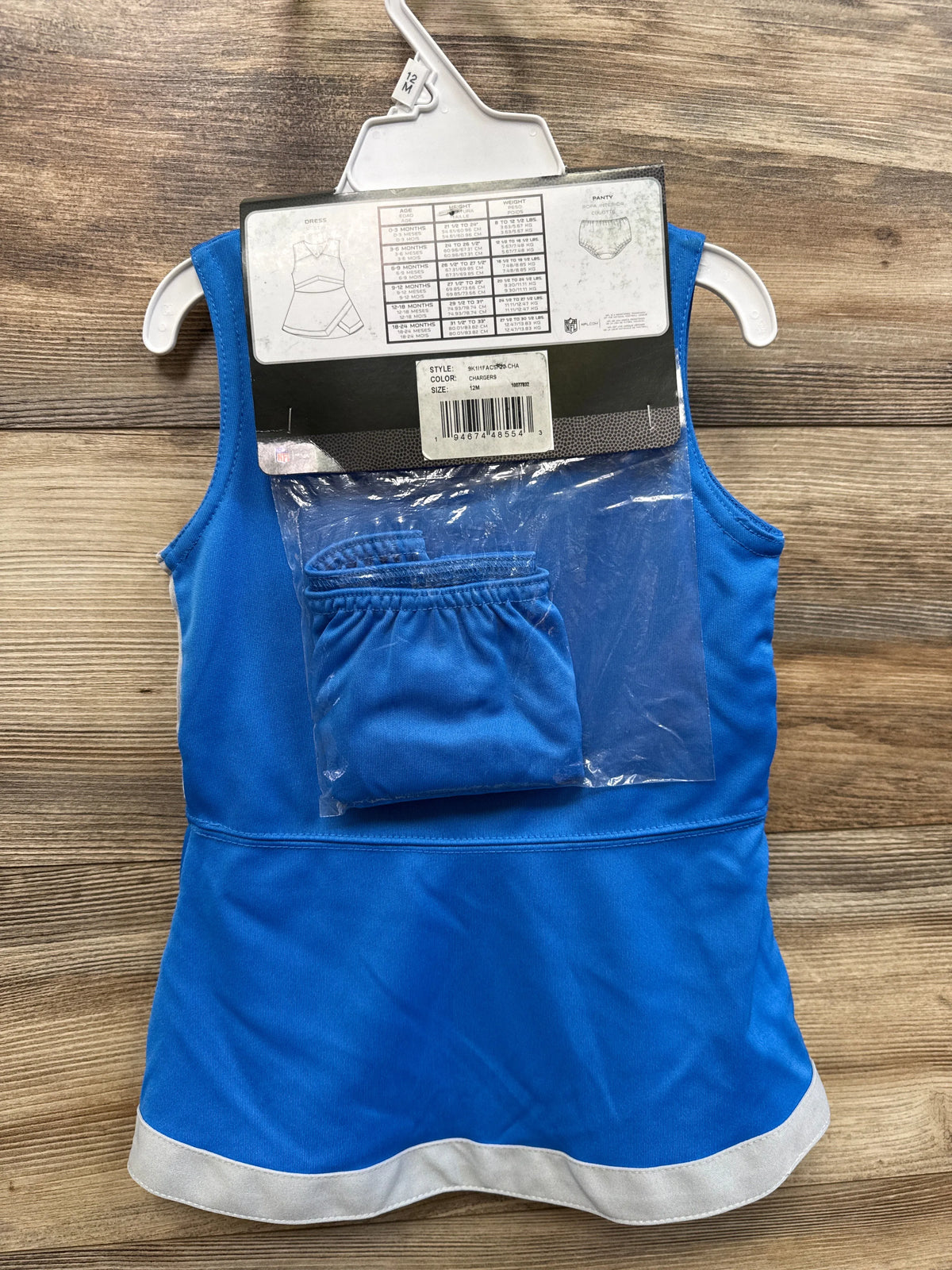 Front view of a blue NFL Chargers cheer captain dress with white trim and matching bloomers on wood