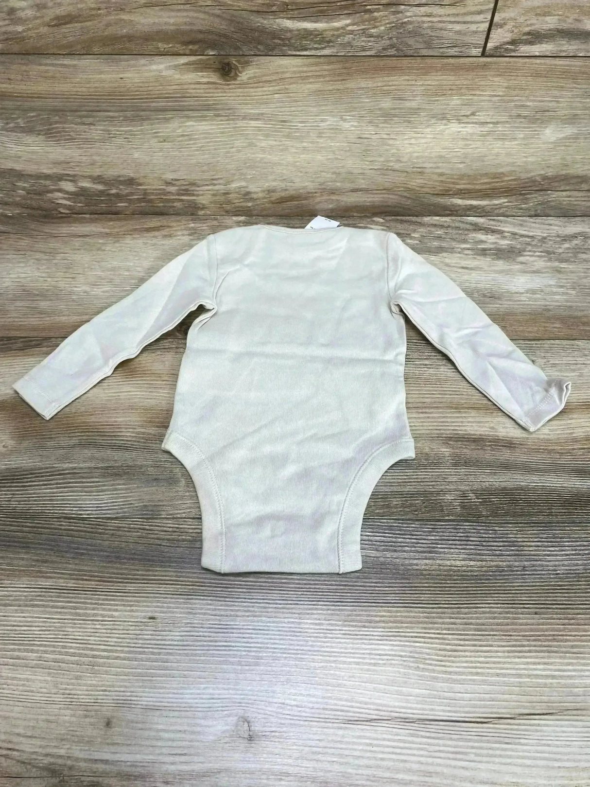 Back view of beige Old Navy long-sleeve baby bodysuit 6 to 12 months showing long sleeves on wood plank background