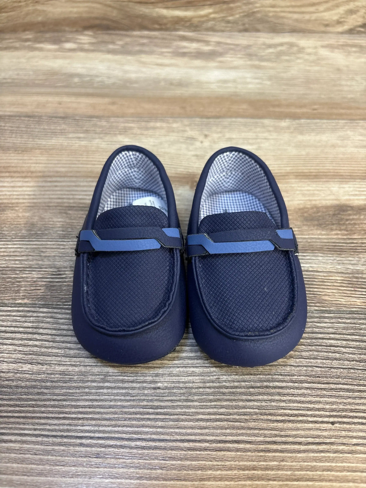 Navy blue baby loafers on wood background, soft sole infant shoes, toddler footwear