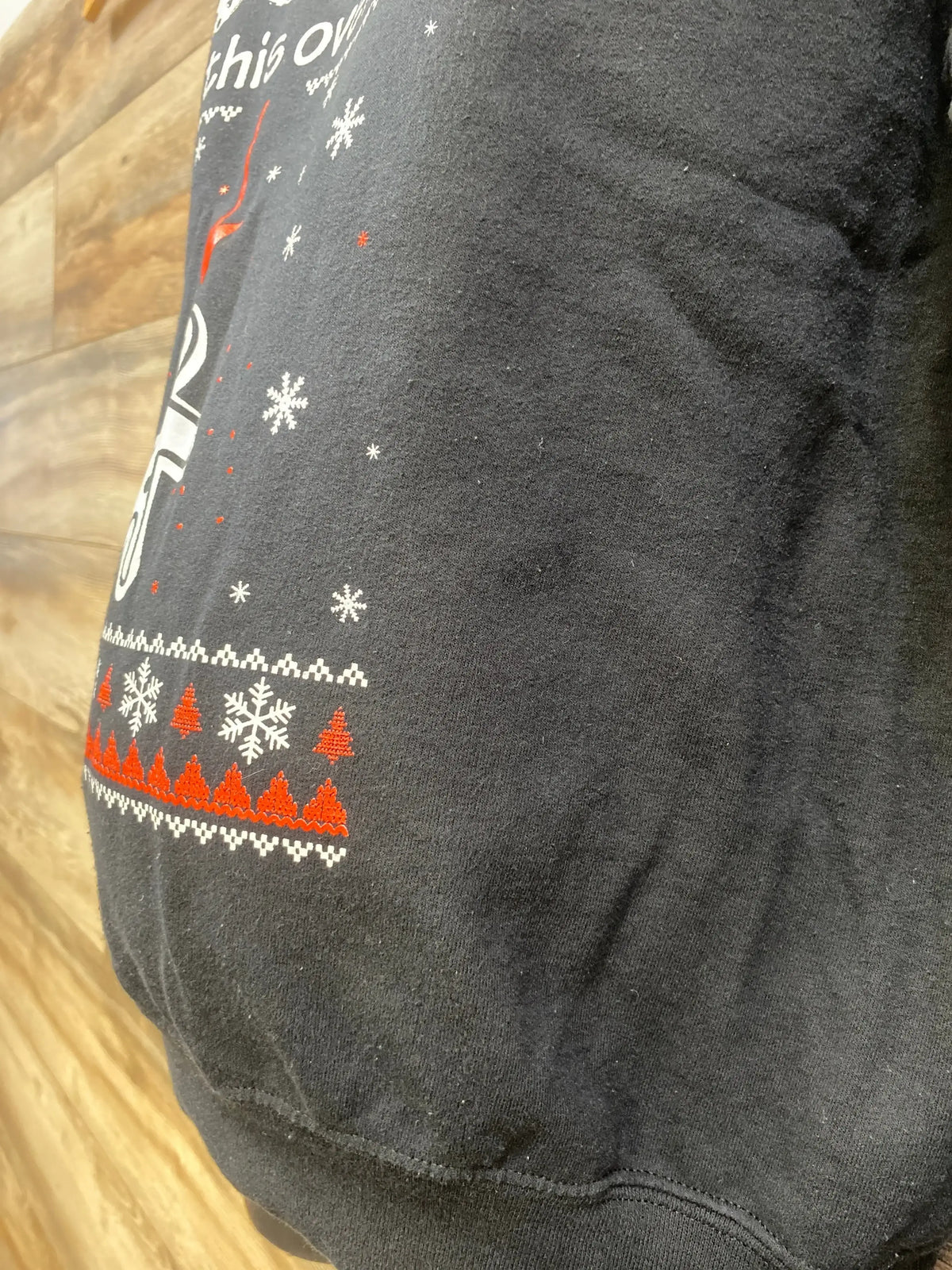 Black holiday sweater with snowflakes, red trees, and festive patterns for kids or maternity wear.