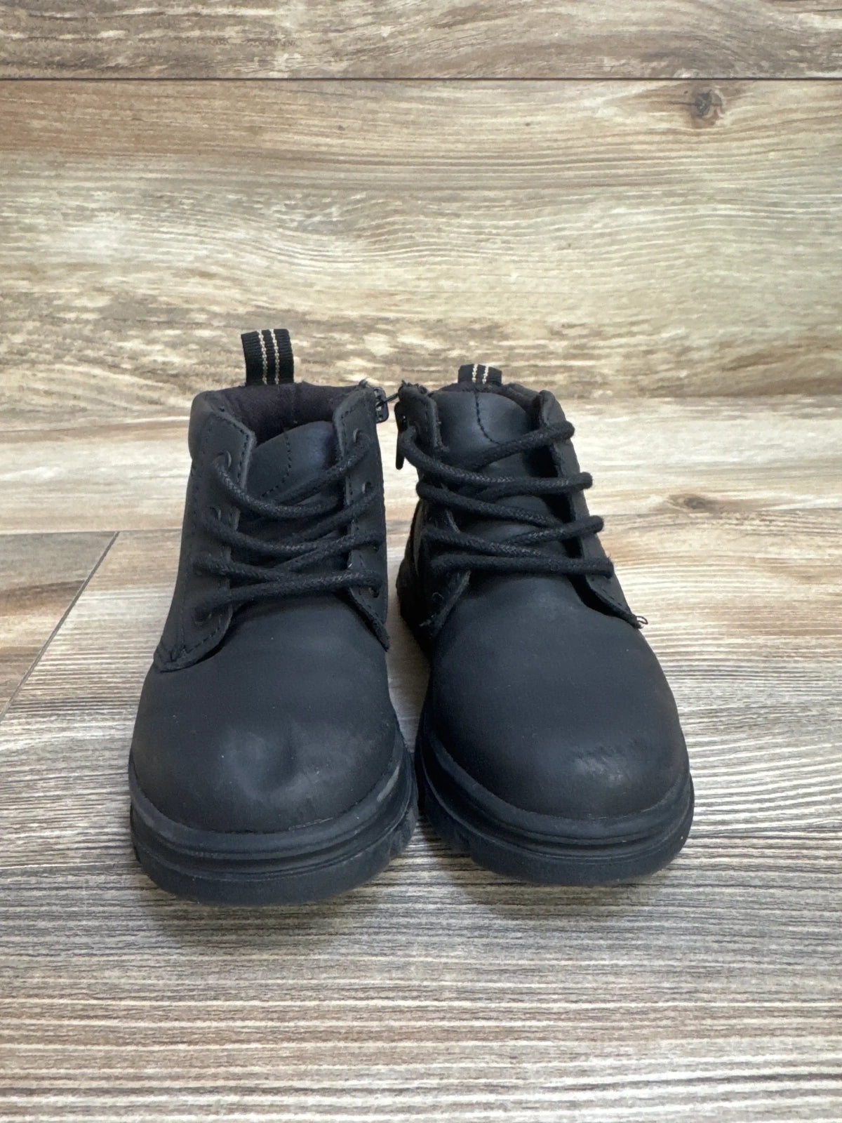 Front view of Zara boy's black side-zip ankle boots, size 7C, showcasing side zipper and lace-up front on light wood floor