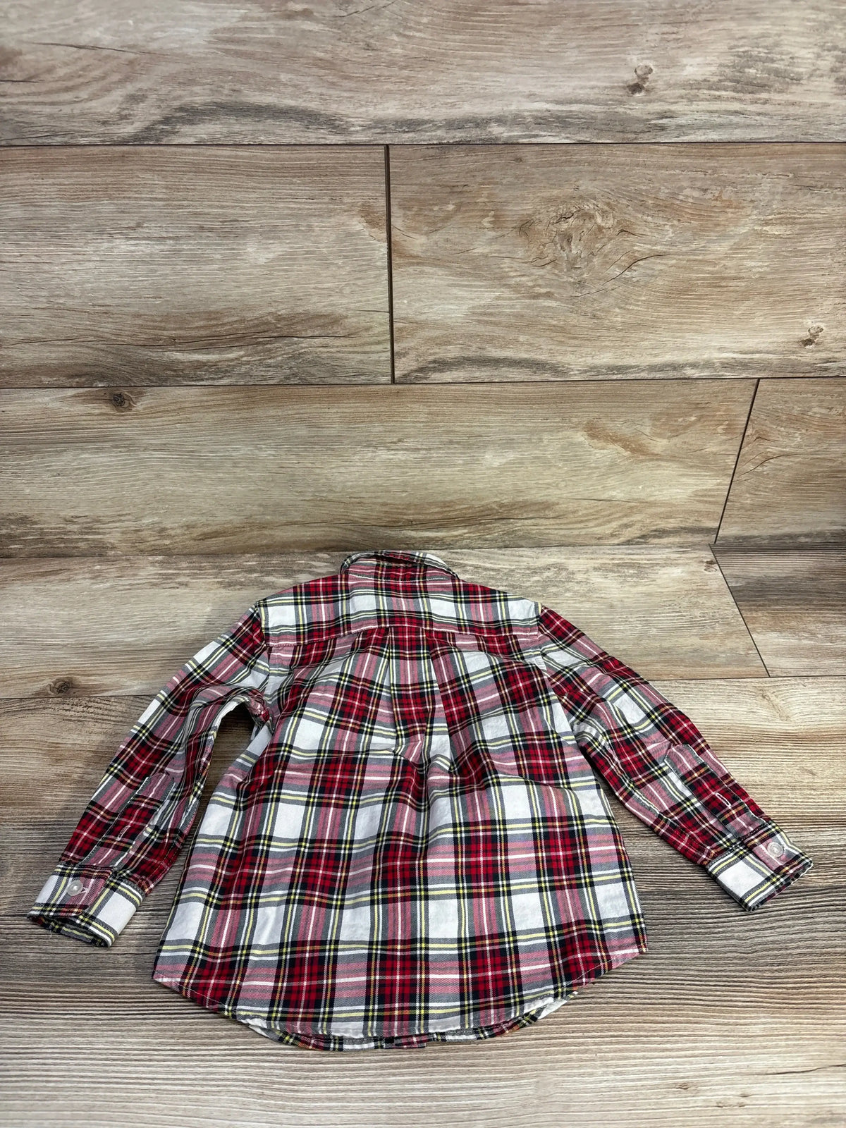 Red plaid long sleeve shirt on wood background