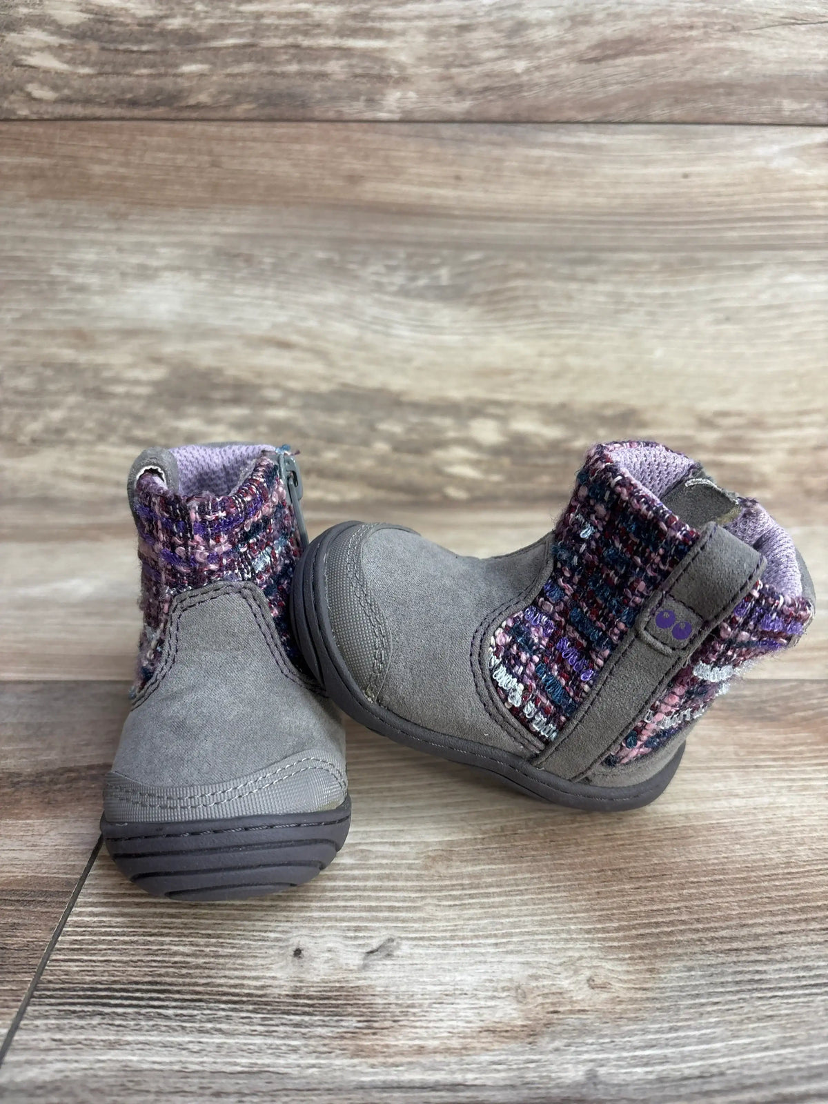 Front and side view of Stride Rite Surprize Adora toddler winter boots showing gray suede with purple knit ankle panels and side zipper on wood floor