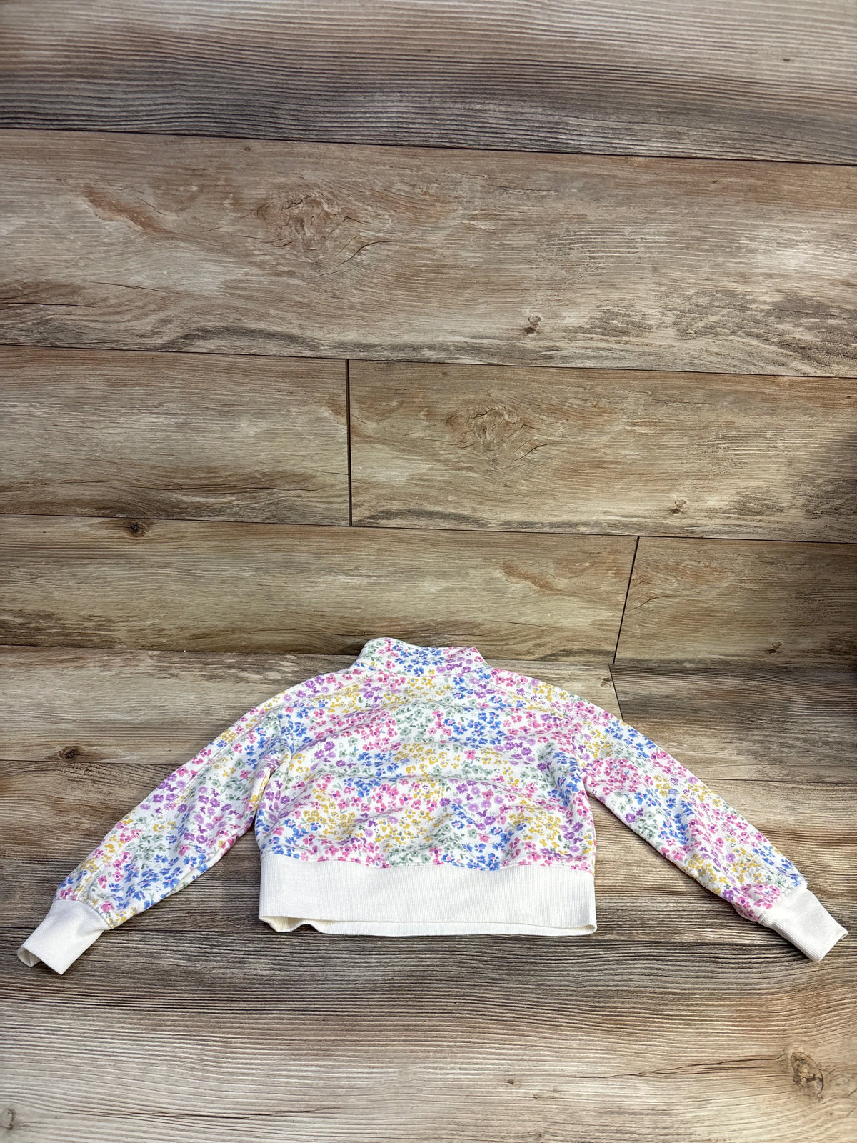 Janie & Jack floral print half-zip sweatshirt in ivory, size 4T, on a wood background