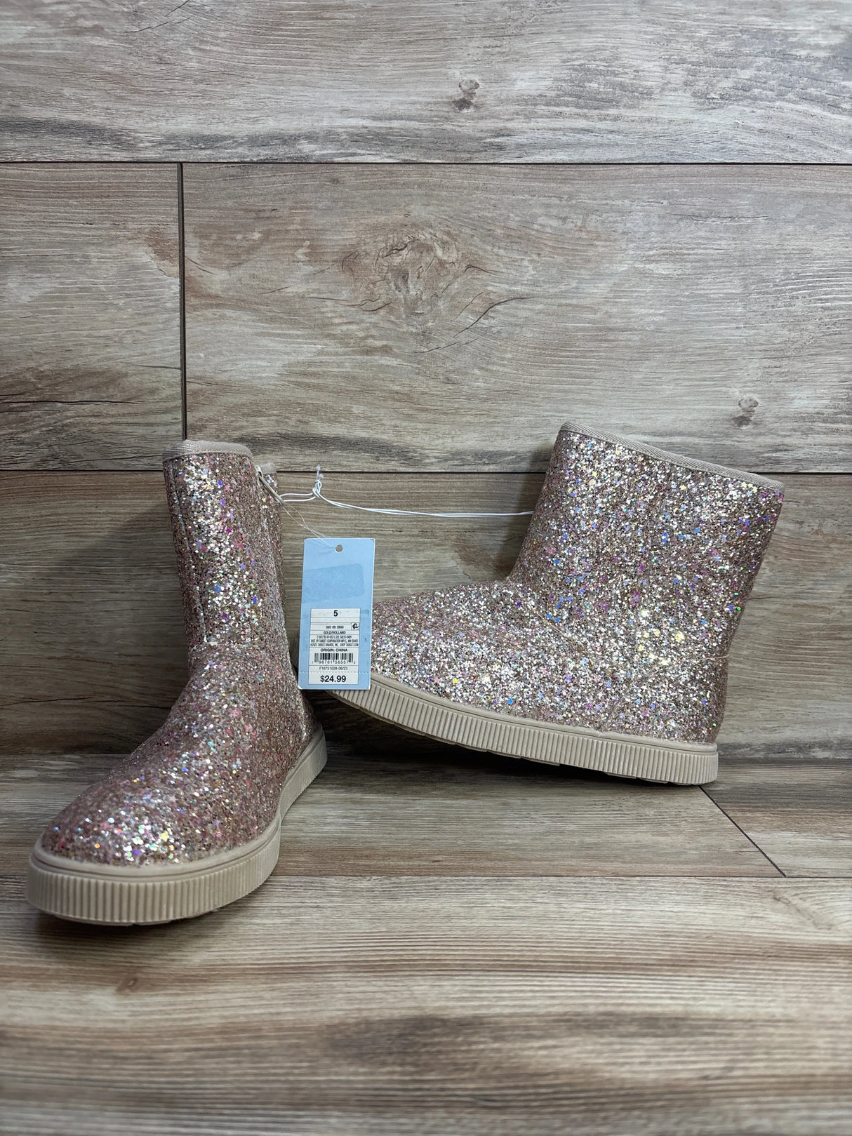 Kids glitter ankle boots with multicolor sparkles and rubber soles on wood background